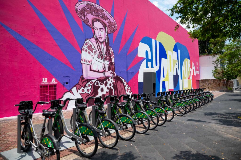 Estación de bicicletas públicas MiBici frente al mural de la charra