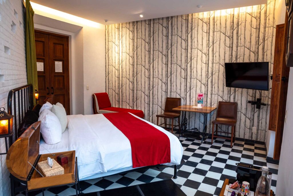 Junior Suite Varo con cama de hierro, tapiz de bosque y piso de ajedrez