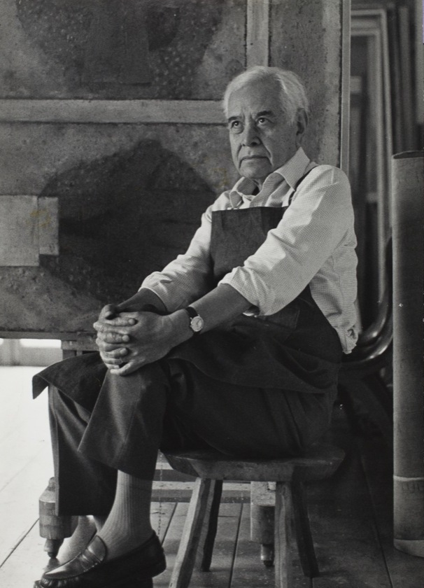 Retrato en blanco y negro del pintor Rufino Tamayo sentado en su estudio