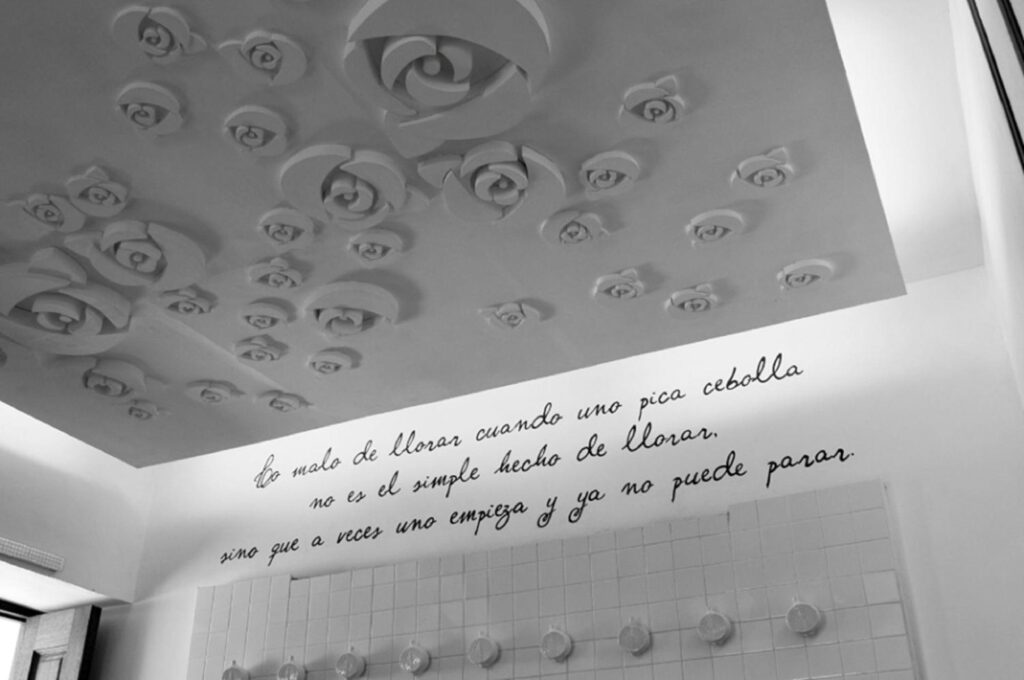 Techo decorado con rosas de yeso y frase poética en el hotel