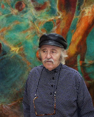 El pintor Vlady retratado frente a una de sus obras